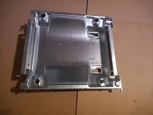 Sockel aus Metall mit mehreren Öffnungen und Einschnitten, möglicherweise für die Montage eines Heizgeräts, von der Marke Remeha.